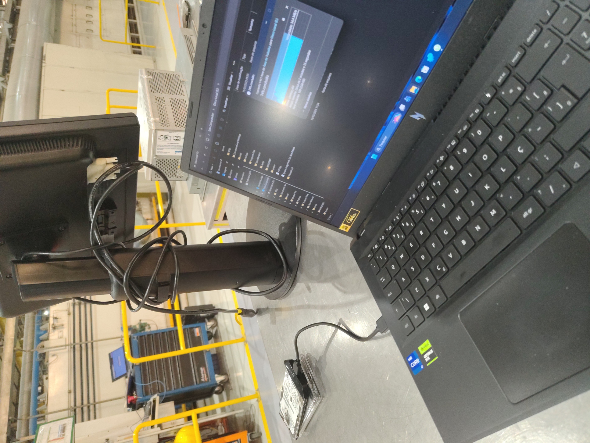 Notebook e dispositivos de armazenamento durante atendimento técnico em ambiente industrial